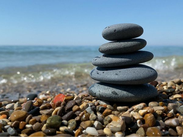 A tranquil scene with stacked stones by the water.